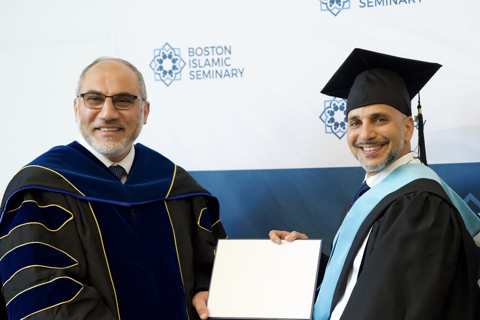 A smiling 2026 BIS graduate with the seminary president at graduation.