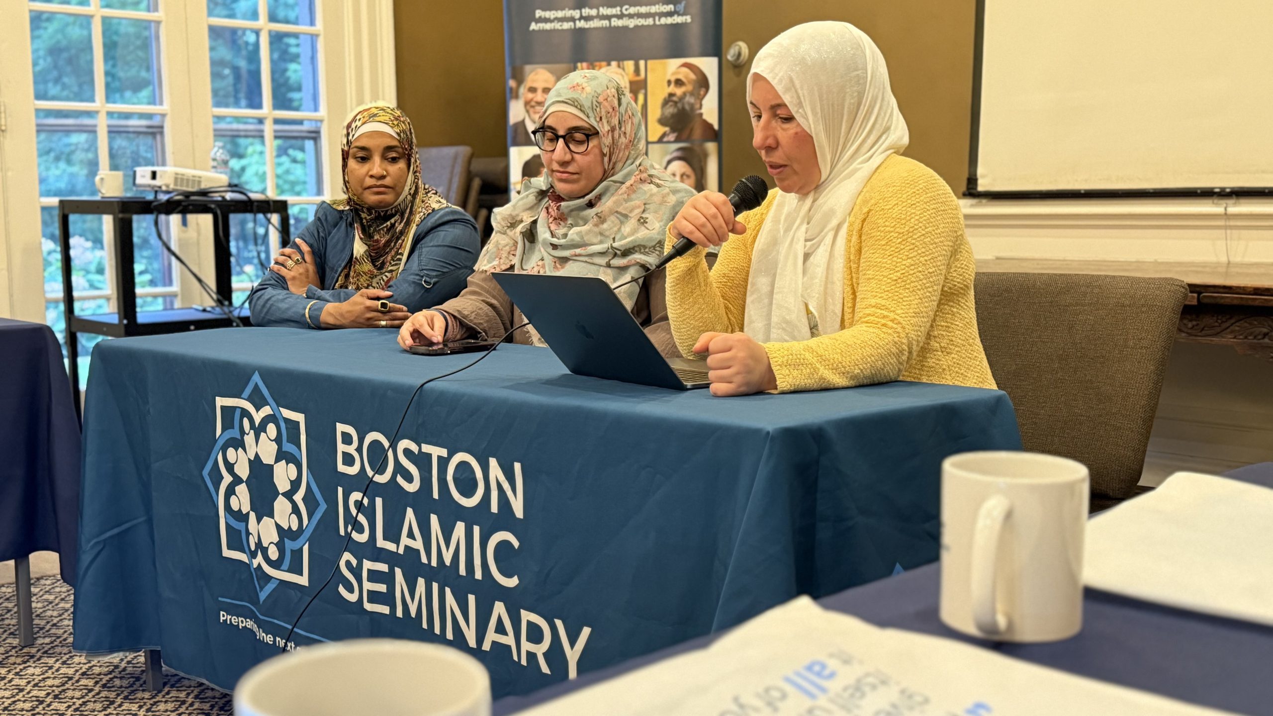 Three participants present together with a laptop and microphone at the BIS academic retreat.